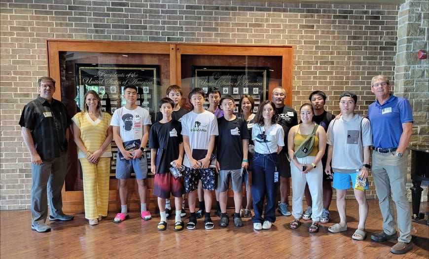 A large group of students and adults posed together in front of a building.